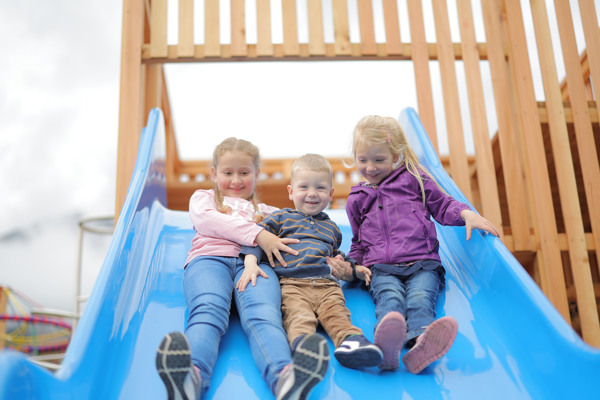 Spielende Kinder auf dem Spielplatz des Dormio Aparthotel Hinterstoder