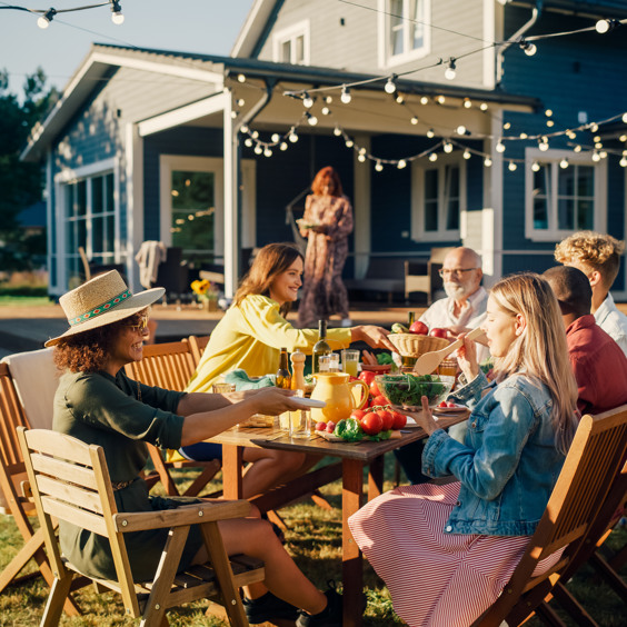 Group of friends eating at the holiday home during the late summer holiday