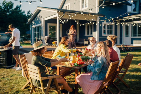 Groep vrienden aan het eten bij de vakantiewoning tijdens de nazomervakantie