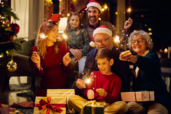 Familie met sterretjes tijdens de jaarwisseling in een vakantiehuisje