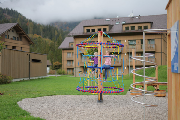 Kinderen aan het spelen in  de speeltuin op Dormio Aparthotel Hinterstoder