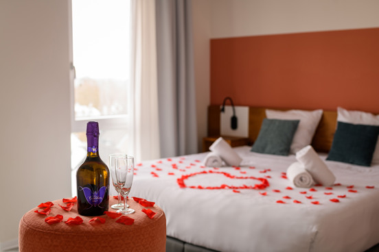 Cama decorada románticamente con pétalos de rosa