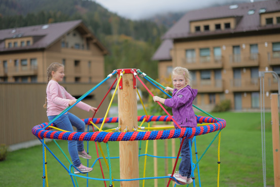Kinderen aan het spelen in de buitenspeeltuin